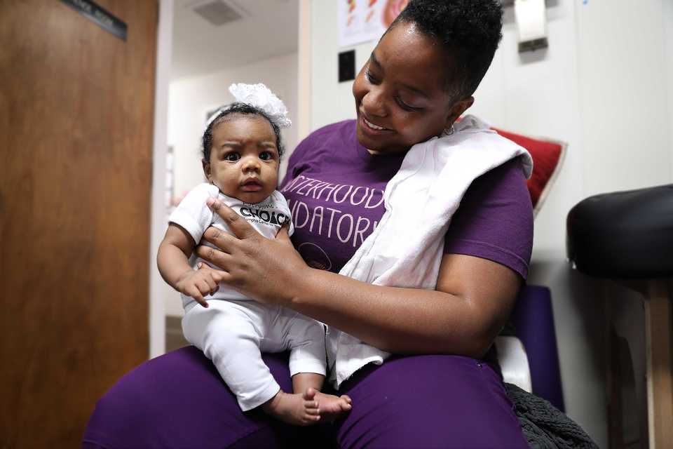 <strong>With young Empress Taylor's mother Ferron Taylor, father and older sister in the room, checkups with CHOICES midwife Nikia Grayson at times seem more like a family reunion than a doctor visit, despite Grayson already seeing roughly 50 patients this year. Grayson was recruited to work for CHOICES as the nonprofit clinic began to expand its range of reproductive health services.</strong> (Patrick Lantrip/Daily Memphian)