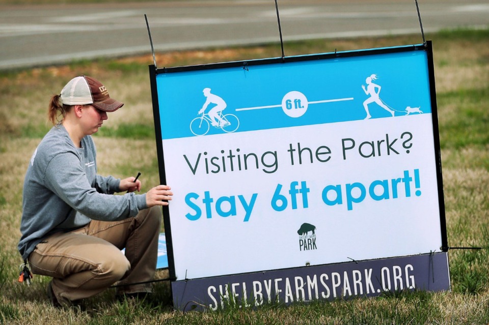 <strong>Ranger Kelsey Price swaps out signs at the Farm Road entrance to Shelby Farms on April 4, 2020, as Memphians practiced social distancing during workouts, dog walks and bike rides.&nbsp;During the COVID-19 pandemic, many visitors said the park has been &ldquo;life changing&rdquo; for them.</strong> (Jim Weber/Daily Memphian file)