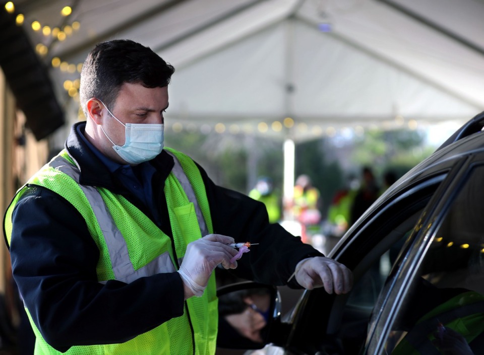 <strong>Reece Halyard with the Collierville Fire Department administers a COVID-19 vaccine at Germantown Baptist Church's new drive through location Feb. 2, 2021.</strong> (Patrick Lantrip/Daily Memphian)