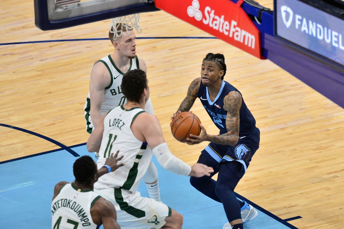 <strong>Grizzlies guard Ja Morant (12) eyes a shot as Milwaukee Bucks center Brook Lopez (11), guard Donte DiVincenzo (0) and forward Thanasis Antetokounmpo (43) close in&nbsp;on March 4 at FedExForum.</strong> (Brandon Dill/AP)