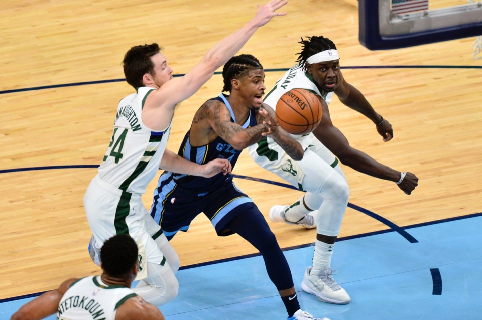 <strong>Grizzlies guard Ja Morant (12) handles the ball between Milwaukee Bucks guards Pat Connaughton (24) and Jrue Holiday on March 4 at FedExForum. </strong>(Brandon Dill/AP)