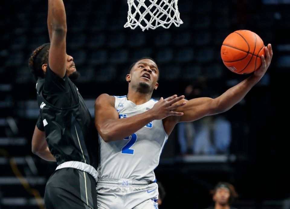 <strong>Tigers guard Alex Lomax (right) drove to the basket against UCF defender Darius Perry during a game in February.</strong> (Mark Weber/The Daily Memphian)