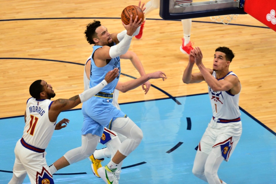 <strong>Memphis Grizzlies guard Dillon Brooks shoots between Denver Nuggets guard Monte Morris (11) and forward Michael Porter Jr. (1)&nbsp;on March 12 at FedExForum.</strong> (Brandon Dill/AP)