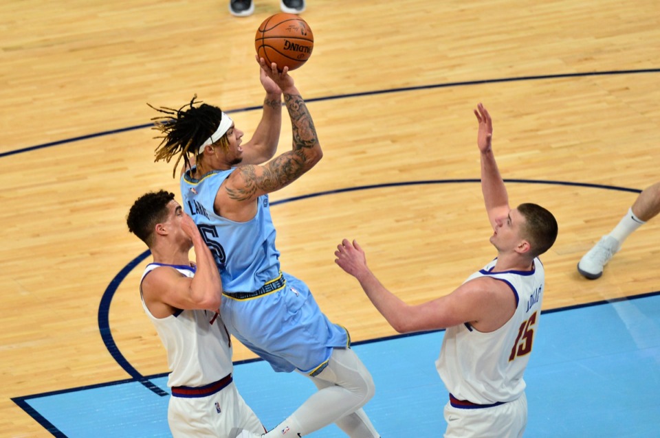 <strong>Memphis Grizzlies forward Brandon Clarke (15) shoots between Denver Nuggets forward Michael Porter Jr., left, and center Nikola Jokic&nbsp;on March 12 at FedExForum.</strong> (Brandon Dill/AP)