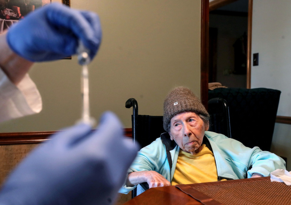 <strong>Mary Rizzo looks at Dr. David Weber as he draws up a COVID-19 vaccine in her Collierville, Tennessee home March 10, 2021.</strong> (Patrick Lantrip/Daily Memphian)