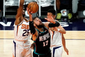 <strong>Memphis Grizzlies center Jonas Valanciunas (17) drives past Phoenix Suns guard Devin Booker and center Deandre Ayton (22) during the second half of an NBA basketball game, Monday, March 15, 2021, in Phoenix. Phoenix won 122-99.</strong> (AP Photo/Rick Scuteri)