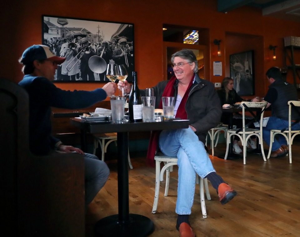 <strong>Greg Thompson (right) and Madison Michael toast during brunch at Second Line on Dec. 20, 2020. Under the new health directive, restaurants and bars serving food may stay open until 1 a.m., and more people may be seated together.</strong> (Patrick Lantrip/Daily Memphian file)