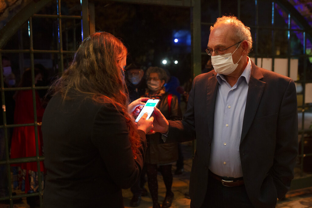 <strong>A man presents his "green passport," proof that he is vaccinated against the coronavirus, on opening night at the Khan Theater for a performance where all guests were required to show proof of vaccination or full recovery from the virus, in Jerusalem, Tuesday, Feb. 23, 2021.</strong> (AP Photo/Maya Alleruzzo)