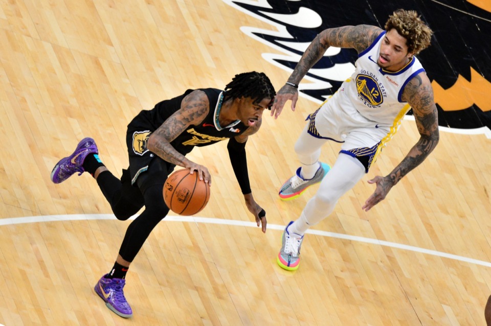 <strong>Grizzlies guard Ja Morant (12) drives past Golden State Warriors guard Kelly Oubre Jr. (12)&nbsp;on March 19 at FedExForum. </strong>(Brandon Dill/AP)