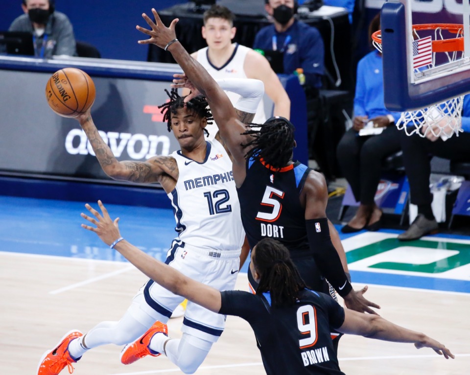 <strong>Grizzlies guard Ja Morant (12) looks to pass against Oklahoma City Thunder forward Luguentz Dort (5) and center Moses Brown (9) on March 24 in Oklahoma City.</strong> (Garett Fisbeck/AP)