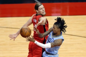 <strong>Grizzlies guard Ja Morant, right, passes the ball behind a surprised Houston Rockets forward Kelly Olynyk, left, on Monday, March 29, in Houston.</strong> (Michael Wyke/AP)
