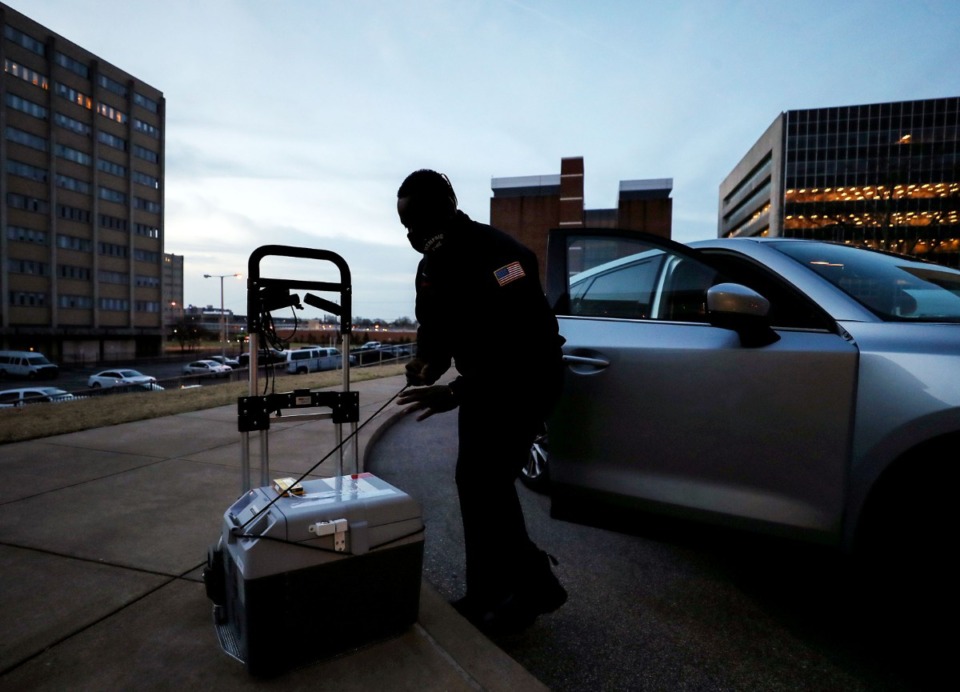 <strong>Firefighter Muhammad Babandi loads a portable cold storage unit containing Pfizer's COVID-19 vaccine outside Regional One Health just before dawn March 16, 2021</strong>. (Patrick Lantrip/Daily Memphian)