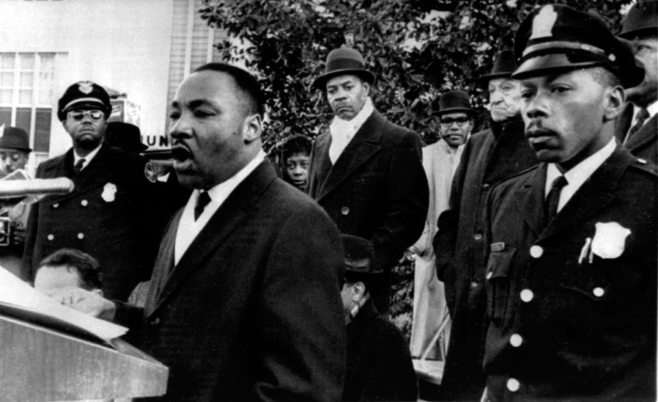 <strong>Dr. Martin Luther King Jr., president of the Southern Christian Leadership Conference, is heavily guarded as he speaks to an estimated crowd of 2,500 who braved freezing weather to attend an anti-segregation rally in downtown Hurt Park Sunday Dec. 16, 1963 in Atlanta.</strong> (AP file)