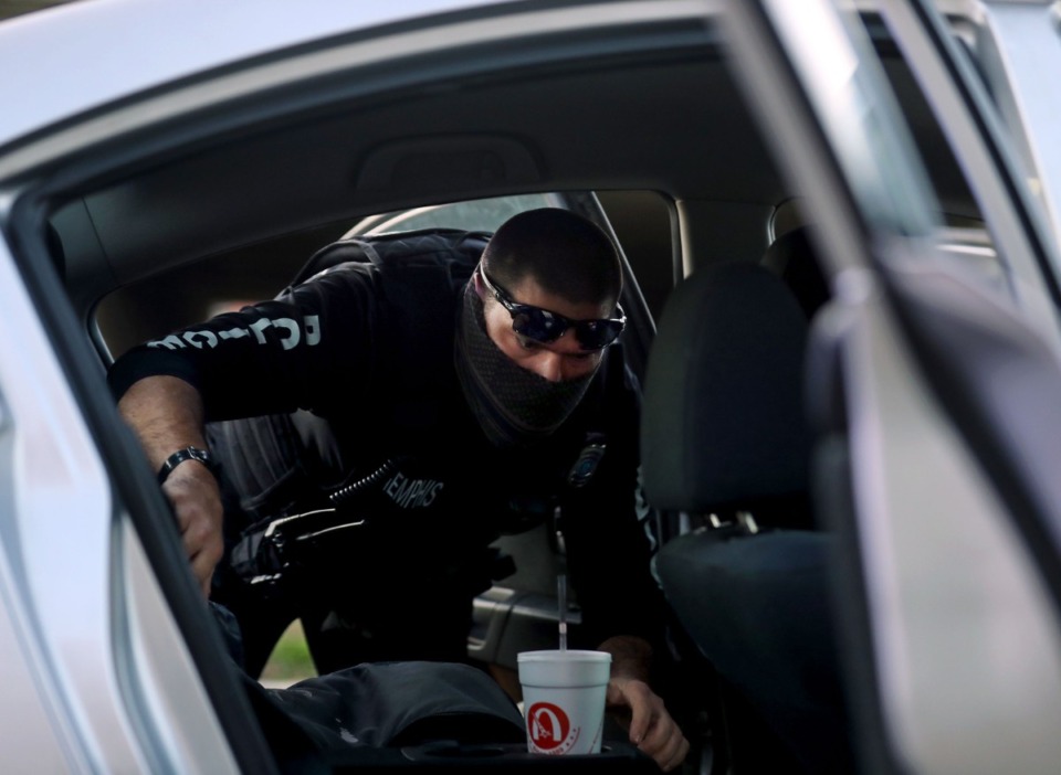<strong>A Memphis Police officer searches a vehicle during an arrest on March 27.</strong> (Patrick Lantrip/Daily Memphian)
