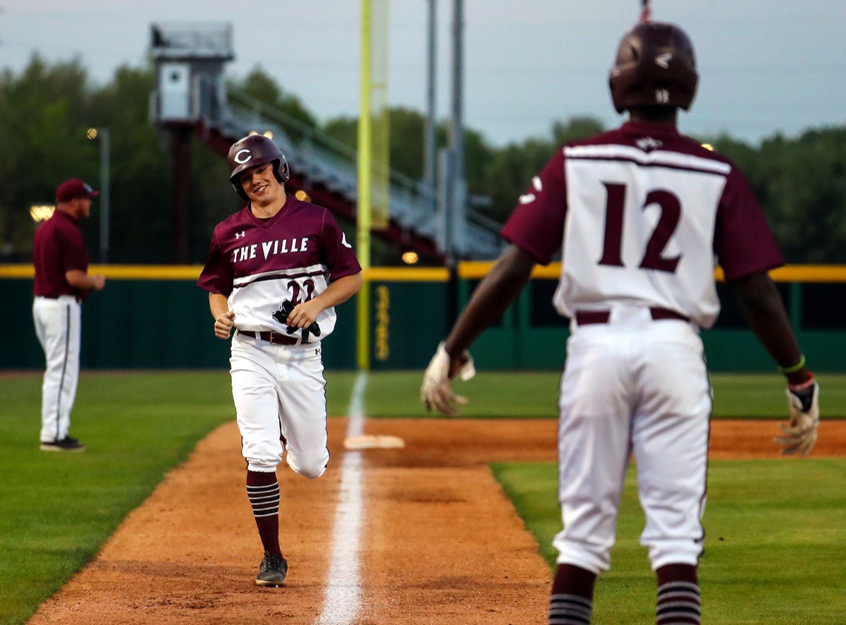 <strong>Collierville outfielder Marcus Lee (12) congratulates fellow outfielder Griffith Baird (22) as he makes his way home during the April 13 game against Arlington.</strong> (Patrick Lantrip/Daily Memphian)
