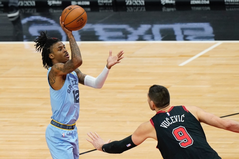 <strong>Grizzlies guard Ja Morant, left, shoots over Chicago Bulls center Nikola Vucevic on April 16 in Chicago.</strong> (Nam Y. Huh/AP)