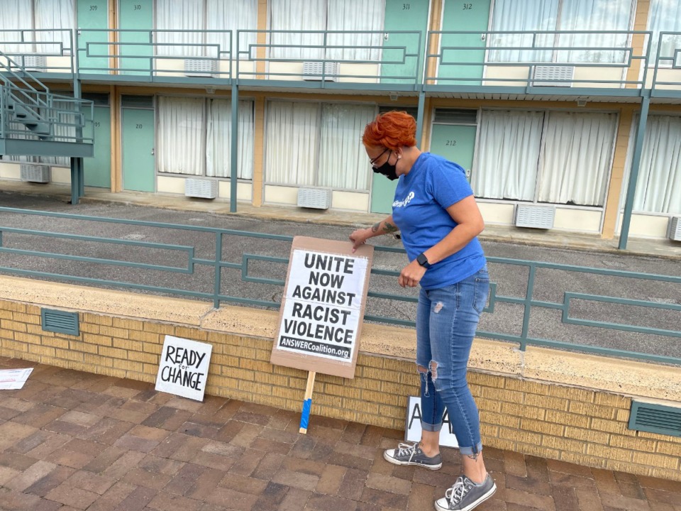 <strong>Memphis activist LJ Abraham puts signs along a wall at the National Civil Rights Museum during protests against recent police shootings on Sunday, April 18, 2021.</strong> (Yolanda Jones/Daily Memphian)