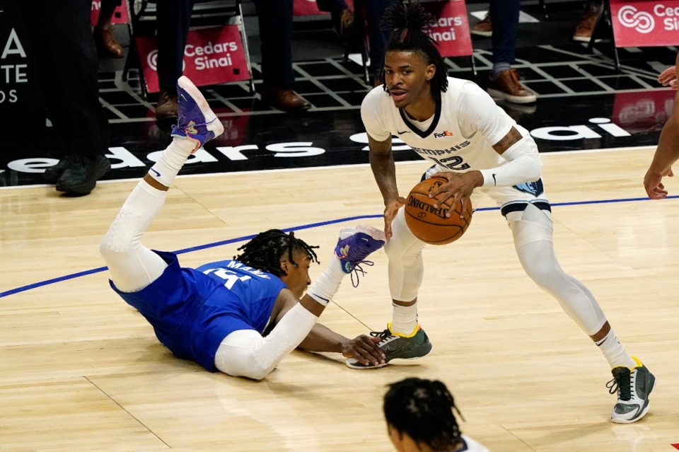 <strong>Los Angeles Clippers guard Terance Mann, left, falls down while guarding Grizzlies guard Ja Morant (12) on April 21 in Los Angeles.</strong> (Marcio Jose Sanchez/AP)