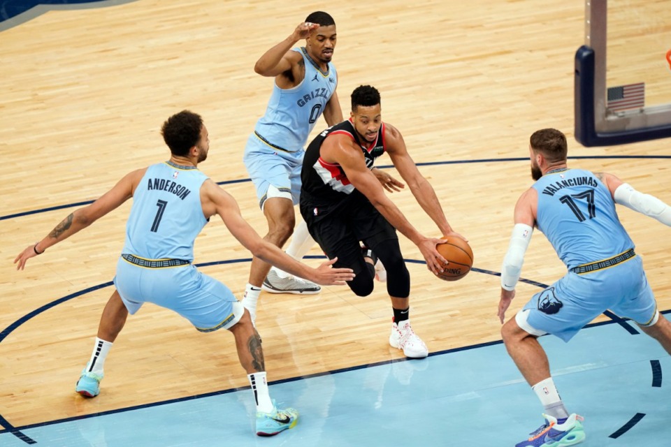 <strong>Portland Trail Blazers' C.J. McCollum, center, drives between Memphis Grizzlies' defenders Kyle Anderson (1), De'Anthony Melton (0) and Jonas Valanciunas (17) in the second half of an NBA basketball game Wednesday, April 28, 2021, at FedExForum.</strong> (Mark Humphrey/AP)
