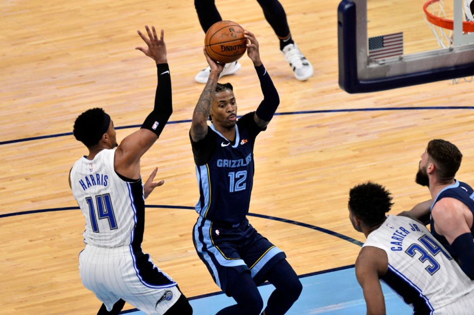 <strong>Grizzlies guard Ja Morant (12) is defended by Orlando Magic guard Gary Harris (14) on April 30 at FedExForum.</strong> (Brandon Dill/AP)