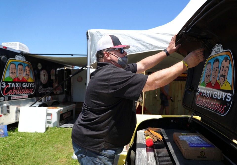 <strong>Ricky Bobby, pitmaster for the 3 Taxi Guys booth, gets his cab-turned-grill ready for the Memphis in May World Championship Barbecue Cooking Contest on Wednesday,&nbsp;May 12.</strong> (Patrick Lantrip/Daily Memphian)