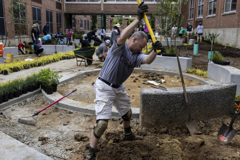 <strong>Richard Myers digs a hole for a tree at White Station High School on Saturday, May 8. Volunteers spent the day working on landscaping in the school&rsquo;s courtyard as part of a project led by Myers.</strong> (Brad Vest/Special to the Daily Memphian)