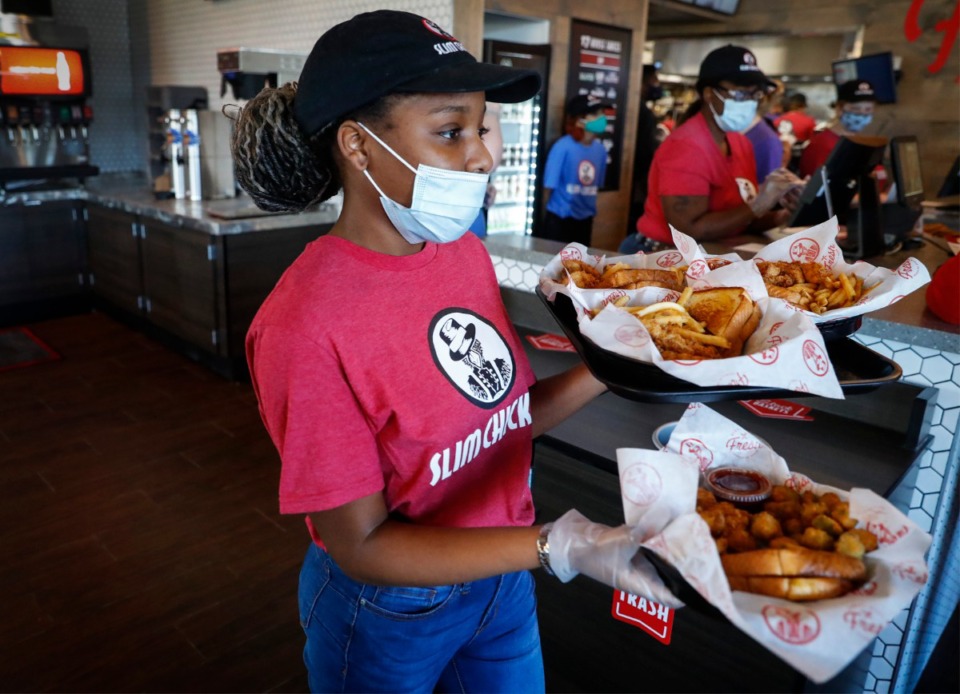 <strong>Server Lovie Pope (in a file photo) delivers food to customers at Slim Chickens restaurant in Collierville.&nbsp;Mike Miller, head of the Memphis Restaurant Association, found Health Directive 21 contradictory, with guidance that seemed to give employers final say in masking and later phrasing that masks were required for workers in public places where they could have contact with nonvaccinated people.</strong> (Mark Weber/The Daily Memphian)