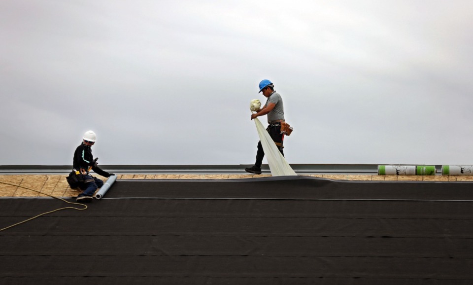 <strong>Construction crews install a roof on a building in The Lake District on Tuesday, May 11.</strong> (Patrick Lantrip/Daily Memphian)