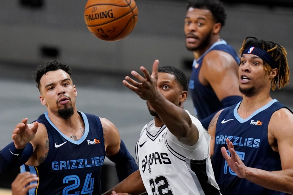 <strong>San Antonio Spurs forward Rudy Gay (22) reaches past Memphis Grizzlies guard Dillon Brooks (24) and forward Brandon Clarke (15) for a rebound on Feb. 1. No franchise looms larger in Grizzlies postseason history than the Spurs.</strong> (Eric Gay/AP file)