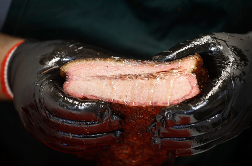<strong>Bryant Bain, co-owner of the Bain's Barbecue, squeezes his brisket to see how juicy it is before opening his food truck on Sunday, May 16, 2021.</strong> (Mark Weber/The Daily Memphian)
