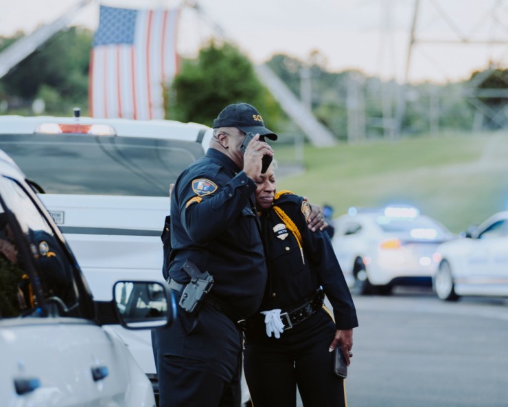 <strong>Two Memphis police officers embrace as a motorcade for the Sea of Blue ceremony pulls out of Hope Presbyterian Church. The officers drove 40-mile route around Memphis in honor of officer Christopher Scott &ldquo;Scotty&rdquo; Triplett. Triplett was killed last week after he was struck by a car while riding his motorcycle in a motorcade near Hickory Hill.</strong>(Houston Cofield/Special To The Daily Memphian)