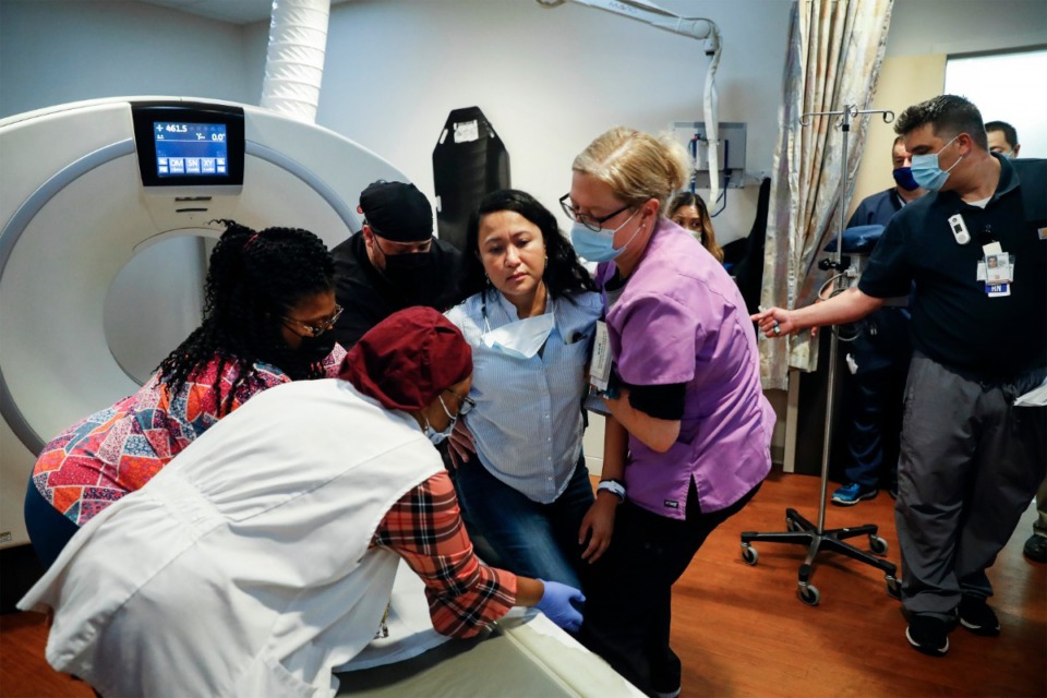 <strong>Memphis VA Medical Center staff members lift a stroke patient, played by VA hospital nurse educator, Joy Barrera, onto a CT scan machine during a Telestroke simulated exercise on Thursday, May 27.</strong> (Mark Weber/Daily Memphian)