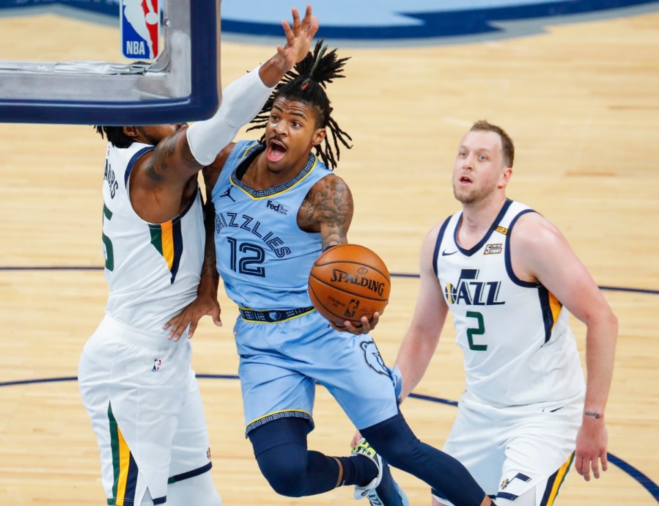 <strong>Memphis Grizzlies guard Ja Morant (middle) drives the lane against Utah Jazz defenders Derrick Favors (left) and Joe Ingles (right) during game three of the NBA Playoffs on Saturday, May 29, 2021.</strong> (Mark Weber/The Daily Memphian)