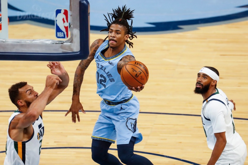 <strong>Memphis Grizzlies guard Ja Morant (middle) drives the lane against Utah Jazz defenders Rudy Gobert (left) and Mike Conley (right) during game three of the NBA Playoffs on Saturday, May 29, 2021.</strong> (Mark Weber/The Daily Memphian)