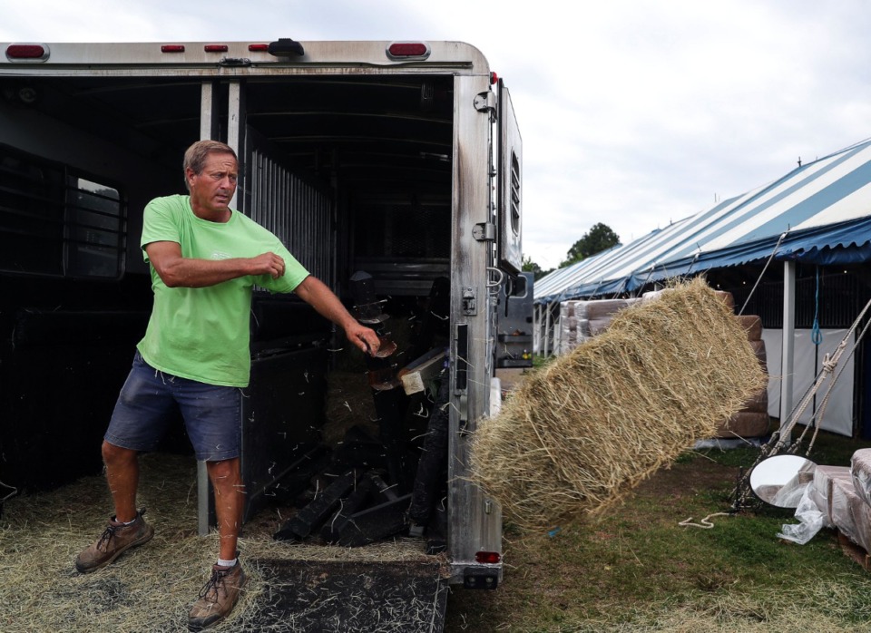 <strong>Beanie Cone unloads a bail of hay in preparation for the Germantown Horse Show June 5, 2021.</strong> (Patrick Lantrip/Daily Memphian)