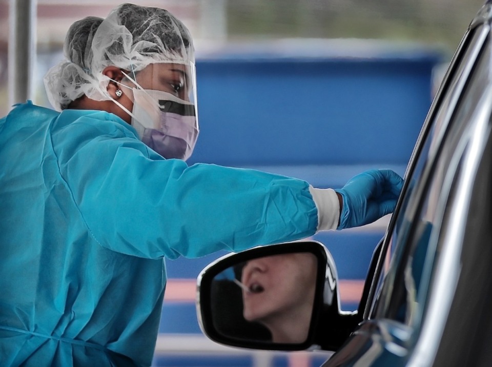 <strong>A nurse tests a drive-thru patient for COVID-19 during a South Memphis clinic in March 2020.</strong> (Jim Weber/Daily Memphian file)