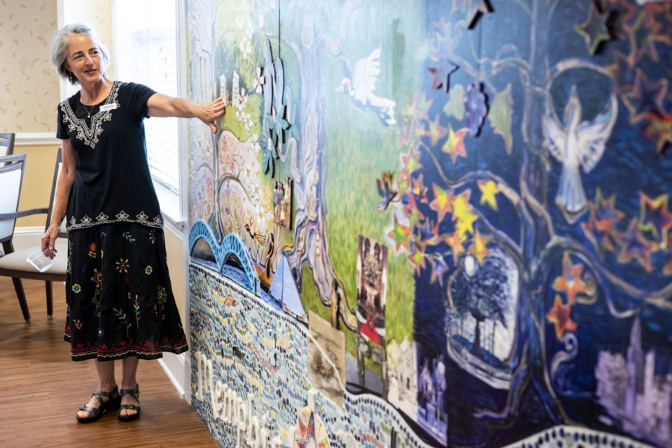 <strong>Artist Kristi Duckworth talks about the mural in the memory care dining room at Trezevant during the mural&rsquo;s unveiling on Thursday, June 24, 2021. The mural tells the history of Memphis from 1930 to 1960, taken from stories from resident Perre Magness&rsquo; books.</strong>&nbsp;(Brad Vest/ Special to The Daily Memphian)