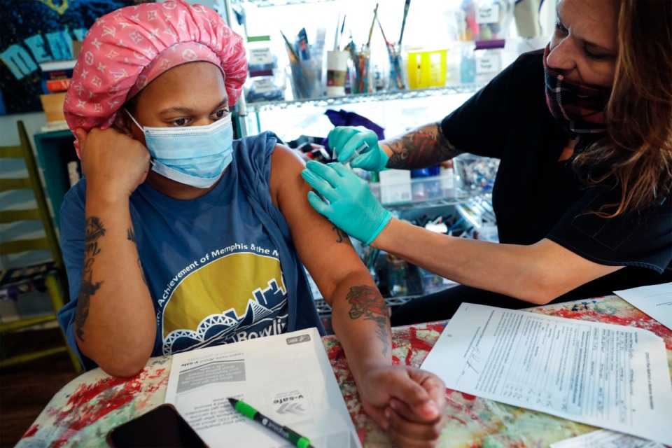 <strong>Kamesha Hammond (left) receives her second coronavirus vaccination shot from Meritan RN Jennifer Mohundro on Wednesday, May 26, 2021 at the Carpenter Art Garden pop-up vaccine site.</strong> (Mark Weber/The Daily Memphian)