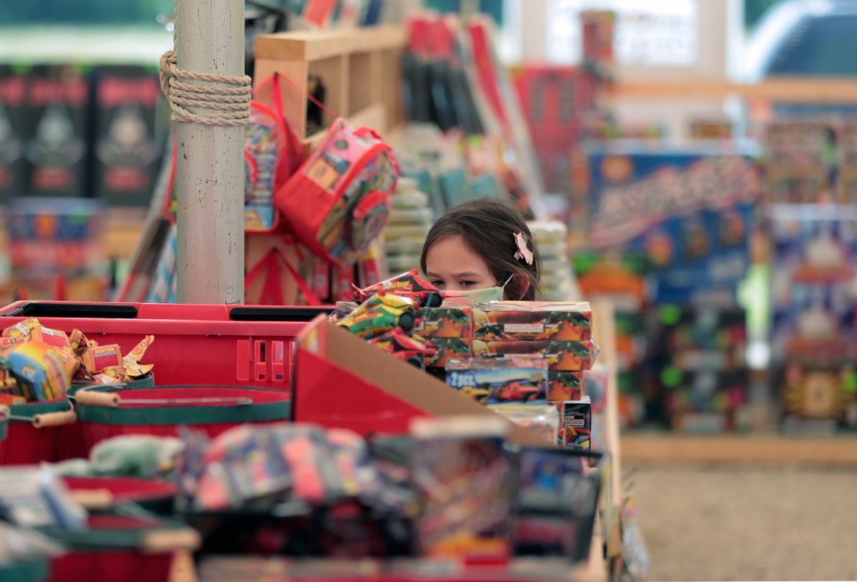 <strong>A young girl eyes a fireworks display almost as tall as she is while shopping with her family at Crazy K Fireworks in Millington July 3, 2020.</strong> (Patrick Lantrip/Daily Memphian file)