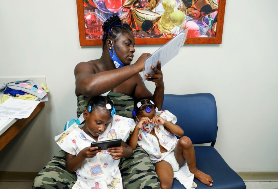 <strong>A mother fills out paperwork for her twin daughters at Le Bonheur Children's Hospital during the girls&rsquo; annual checkup.</strong> (Mark Weber/Daily Memphian file)