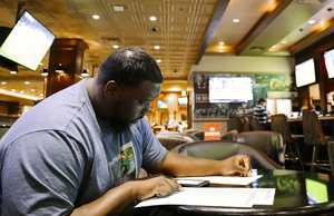 <strong>Mario McKillion, a guest of Horeshoe Casino places bets on football at the casino's one-month-old sport betting lounge in September, 2018, after Mississippi joined Neveda, Delaware, New Jersey and West Virginia in making sports betting legal in the state. From August through the end of 2018, Mississippi&rsquo;s sports books accepted $157.6 million in sports wagers. In the Tunica Region, just over $36 million was wagered at sports books.</strong> (Houston Cofield/Daily Memphian file)