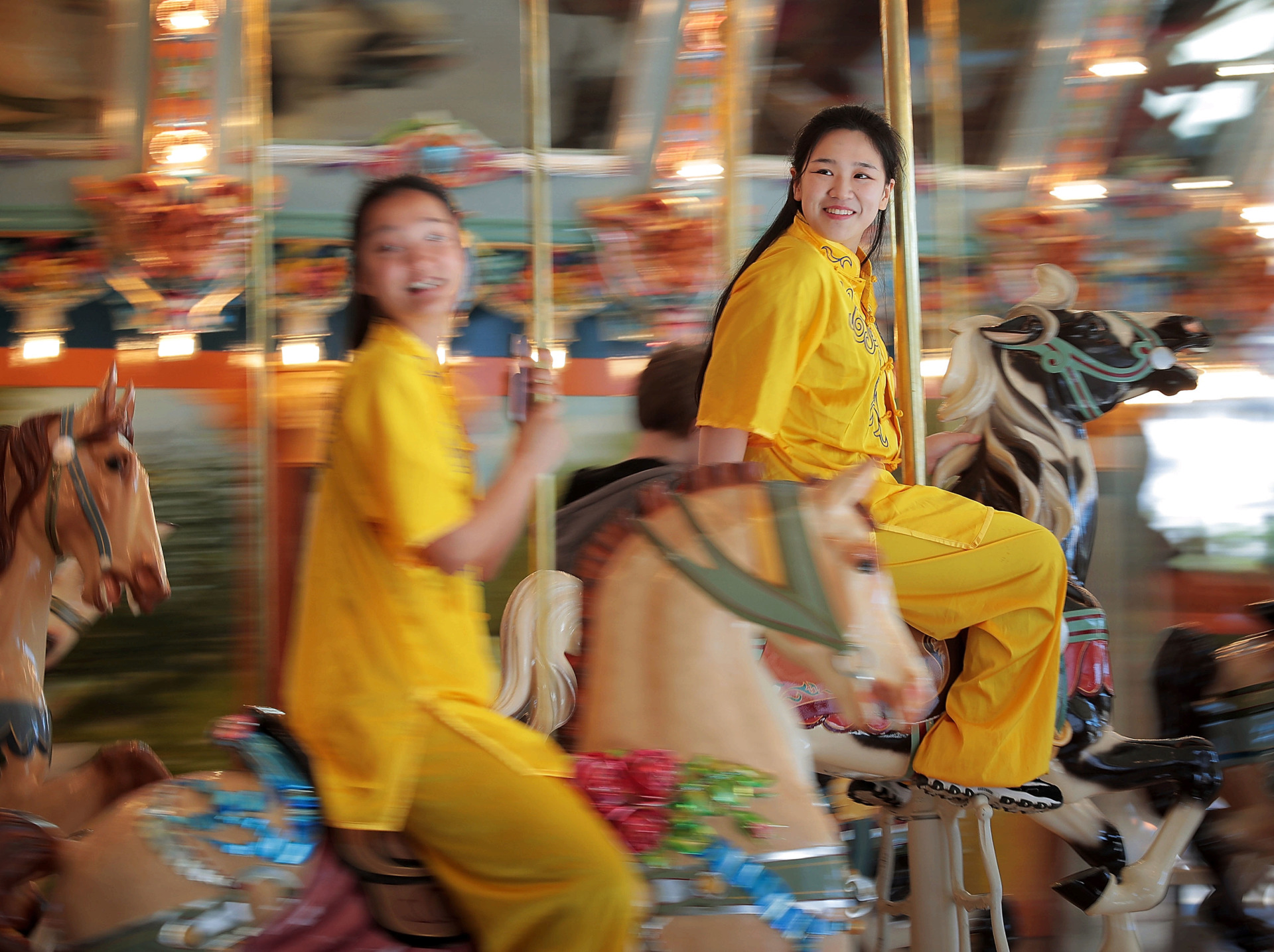 <strong>University of Memphis students Zhinen Guo (left) and Zhuoqun Rao ride the merry-go-round during a Chinese New Year celebration conducted by the Confucius Institute at the Children's Museum of Memphis on Saturday, Feb. 2. The Confucius Institute at the University of Memphis, which was founded more than 12 years ago, conducts community cultural outreach programs in Memphis with dance, crafts and martial arts demonstrations at schools, libraries and international festivals.</strong> (Jim Weber/Daily Memphian)