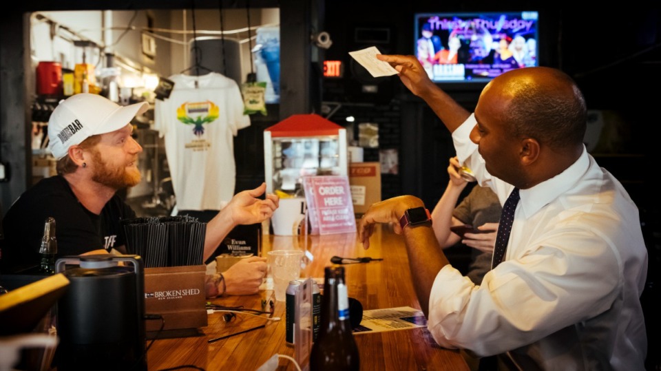 <strong>Shelby County Mayor Lee Harris shows proof of COVID-19 vaccination to bartender Bradley Moore at Dru's Bar on Aug. 6, 2021.</strong> (Ziggy Mack/Special to The Daily Memphian)