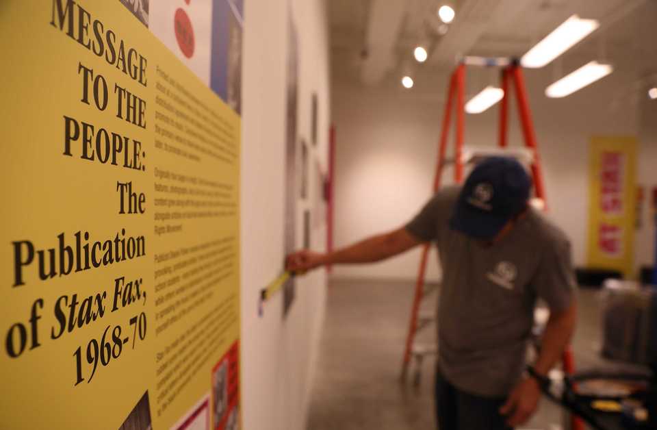 <strong>Eric Berg hangs an assortment of Memphis memorabilia Tuesday, Sept. 25, for a new exhibition at Crosstown Arts, "Give a Damn! Music + Activism at Stax Records," which draws its name from a 1970s Staple Singers song. The exhibition, a look at Stax Records&rsquo; community engagement throughout the decades, opens Friday, Sept. 28.</strong> (Patrick Lantrip/Daily Memphian)