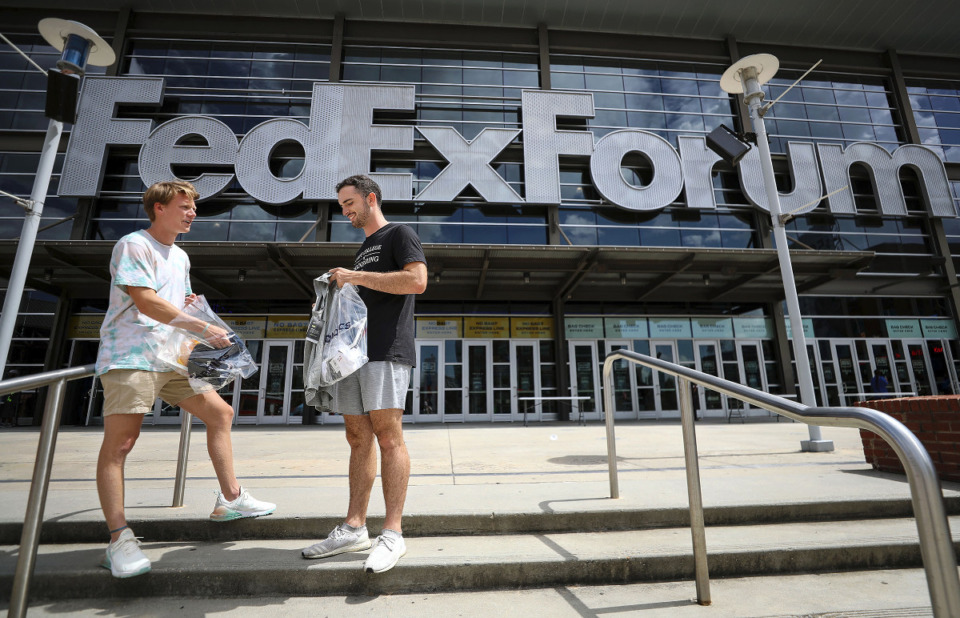 <strong>Alex Robinson (left) and Garrett Whitehorn check out thier goods after leaving the Grizzlies Garage Sale at the FedExForum Aug. 28, 2021.</strong> (Patrick Lantrip/Daily Memphian)