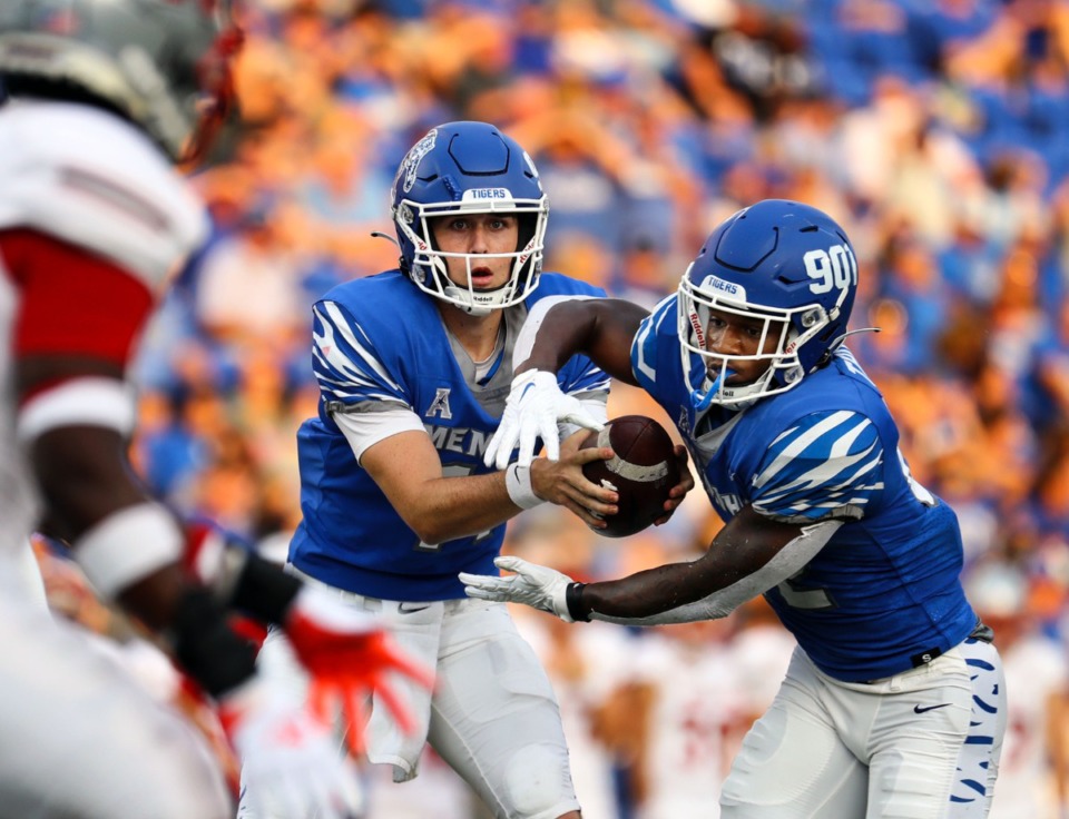 <strong>University of Memphis quarterback Seth Henigan hands the ball off to running back Brandon Thomas during a Sept. 4, 2021 game against Nicholls State at Liberty Bowl Memorial Stadium. Henigan became the first freshman quarterback in school history to start in a season opener for the Tigers, and he led them to a 42-17 win.</strong> (Patrick Lantrip/Daily Memphian)