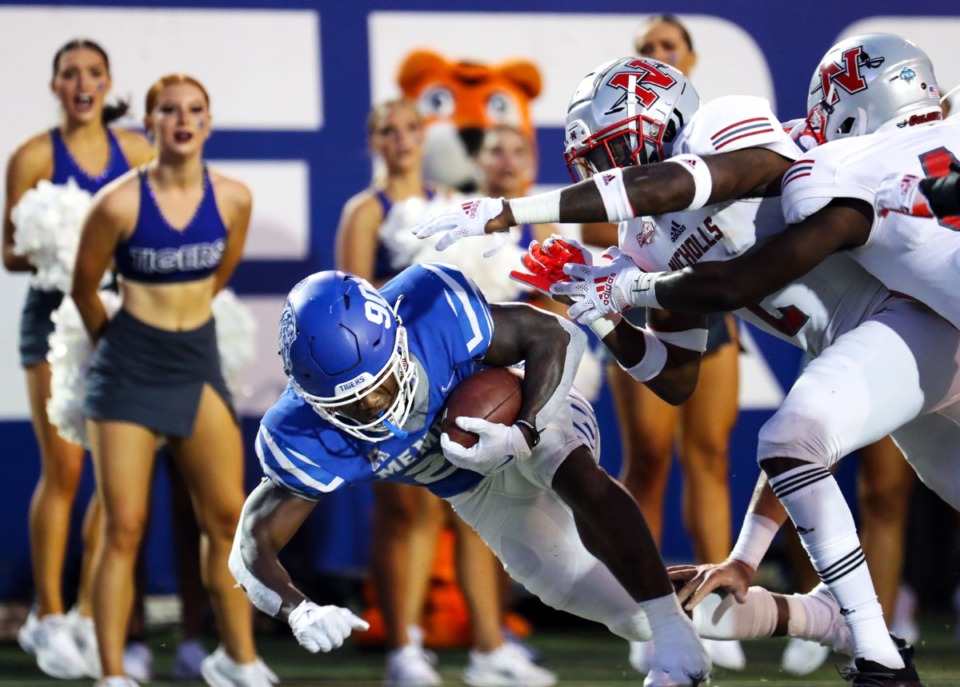 <strong>Running back Brandon Thomas fends off Nicholls State players&rsquo; attempts to grab the ball.</strong> (Patrick Lantrip/Daily Memphian)