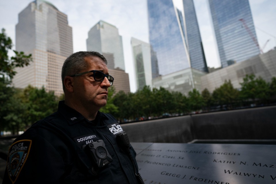 <strong>NYPD officer Michael Dougherty, a 25-year veteran, stands beside the south reflecting pool of the 9/11 Memorial &amp; Museum where names of his deceased colleagues and friends are displayed.</strong> (John Minchillo/AP
