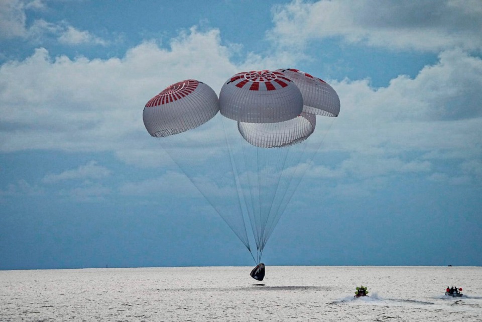 <strong>The SpaceX capsule carrying four people parachutes into the Atlantic Ocean off the Florida coast, Saturday, Sept. 18. The all-amateur crew was the first to circle the world without a professional astronaut.</strong> (SpaceX via AP)