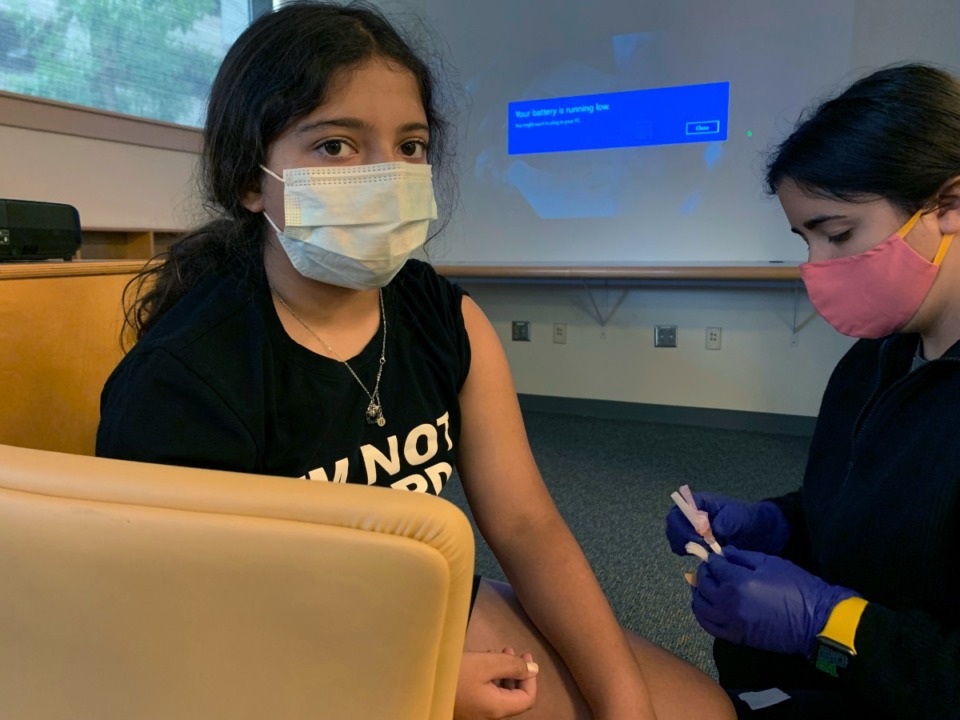 <strong>This photo provided by Nisha Gandhi shows Maya Huber taking part in Pfizer COVID-19 vaccine study at Rutgers University on June 14 2021 in New Brunswick, New Jersey. Maya does not know if she is receiving the vaccine or the placebo. Pfizer says its COVID-19 vaccine works for children ages 5 to 11. The vaccine maker said Monday, Sept. 20, it plans to seek authorization for this age group soon in the U.S., Britain and Europe. The vaccine made by Pfizer and its German partner BioNTech already is available for anyone 12 and older.</strong> (Nisha Gandhi via AP)